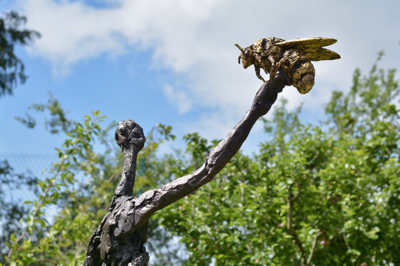bronze woman and bee sculpture