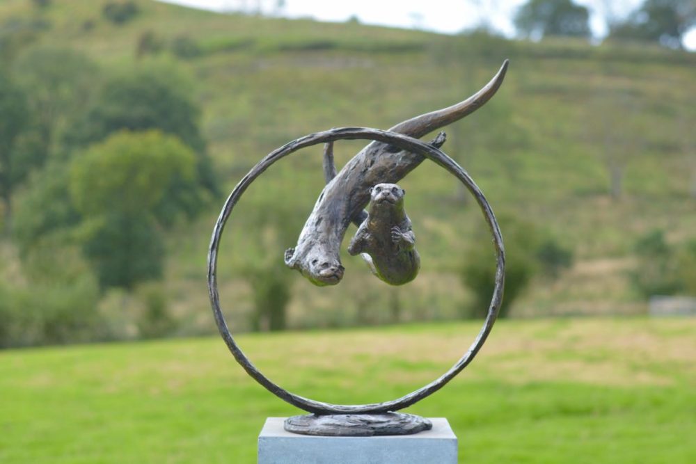 Otters Swimming through ring Statue
