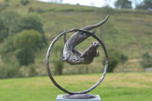 Otters Swimming through ring Sculpture