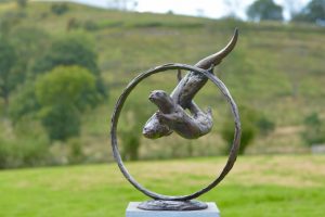 Foundry Bronze Otters Swimming through Ring