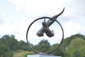 'THROUGH CLEAR WATER' OTTERS SWIMMING THROUGH RING SCULPTURE
