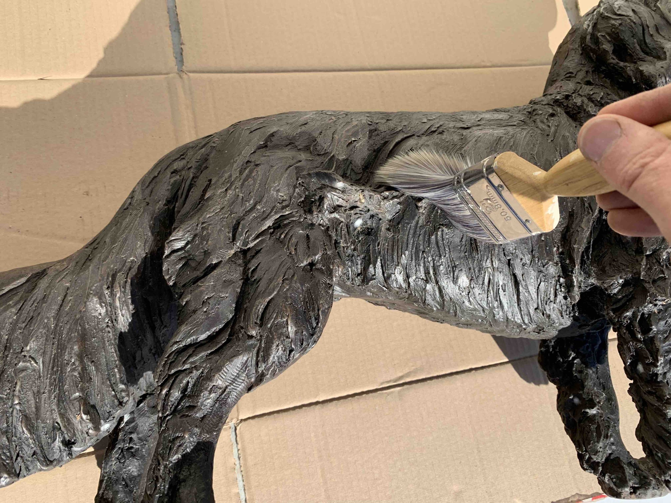 cleaning of a bronze sculpture with a paintbrush