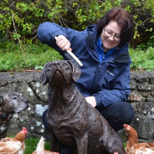 Tanya cleaning a bronze dog sculpture
